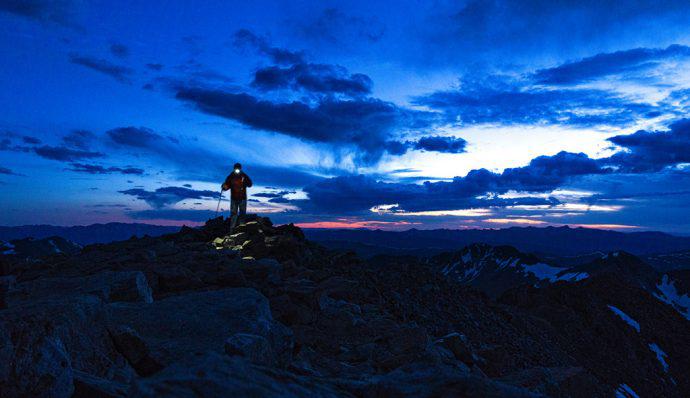 Hiker walks in the mountains at night 