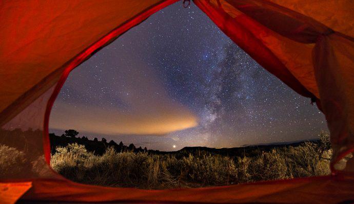 The view of the night's sky from within a red tent