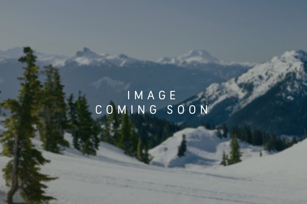 man stands outside tent in the mountains
