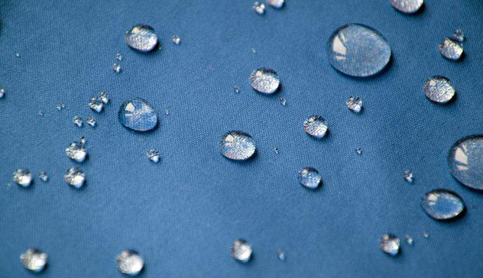 Beads of water sit on fabric