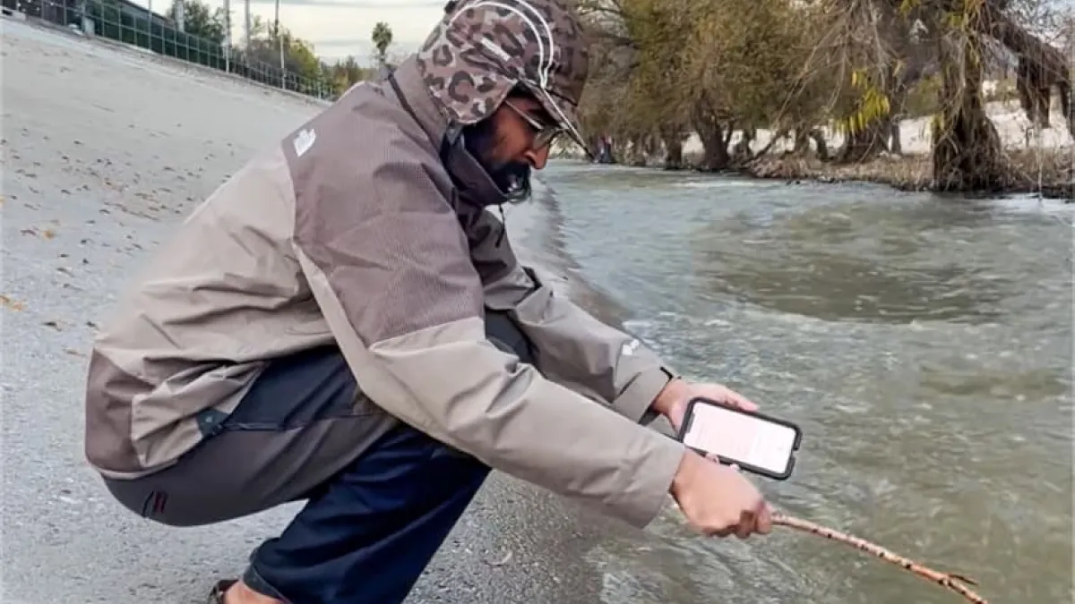 Nikki kneeling at a canal, capturing audio