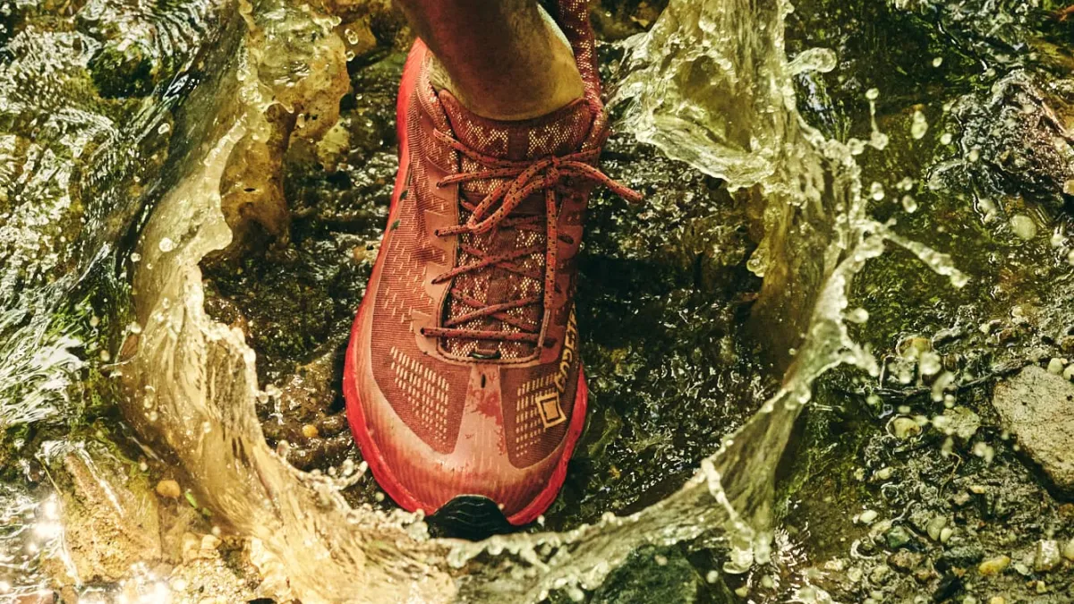 Runner going through a puddle, wearing a Merrell/GORE-TEX Shoe