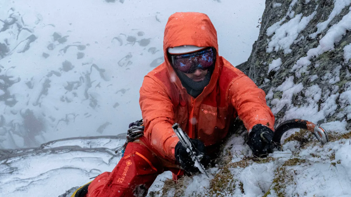 Man ice climbing, wearing orange GORE-TEX Pro Garments