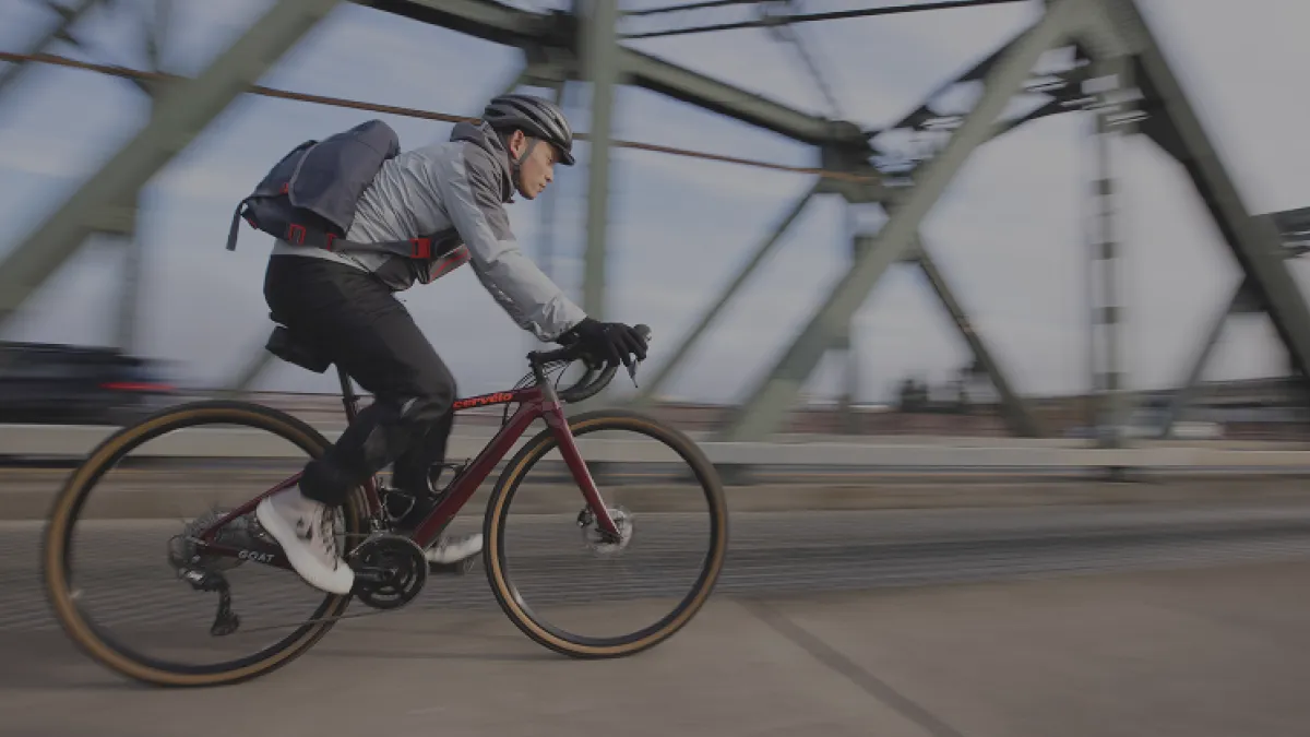 Man biking over a city bridge