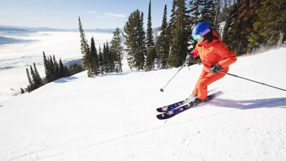 A skier descending a slope wearing GORE-TEX ski rental clothing